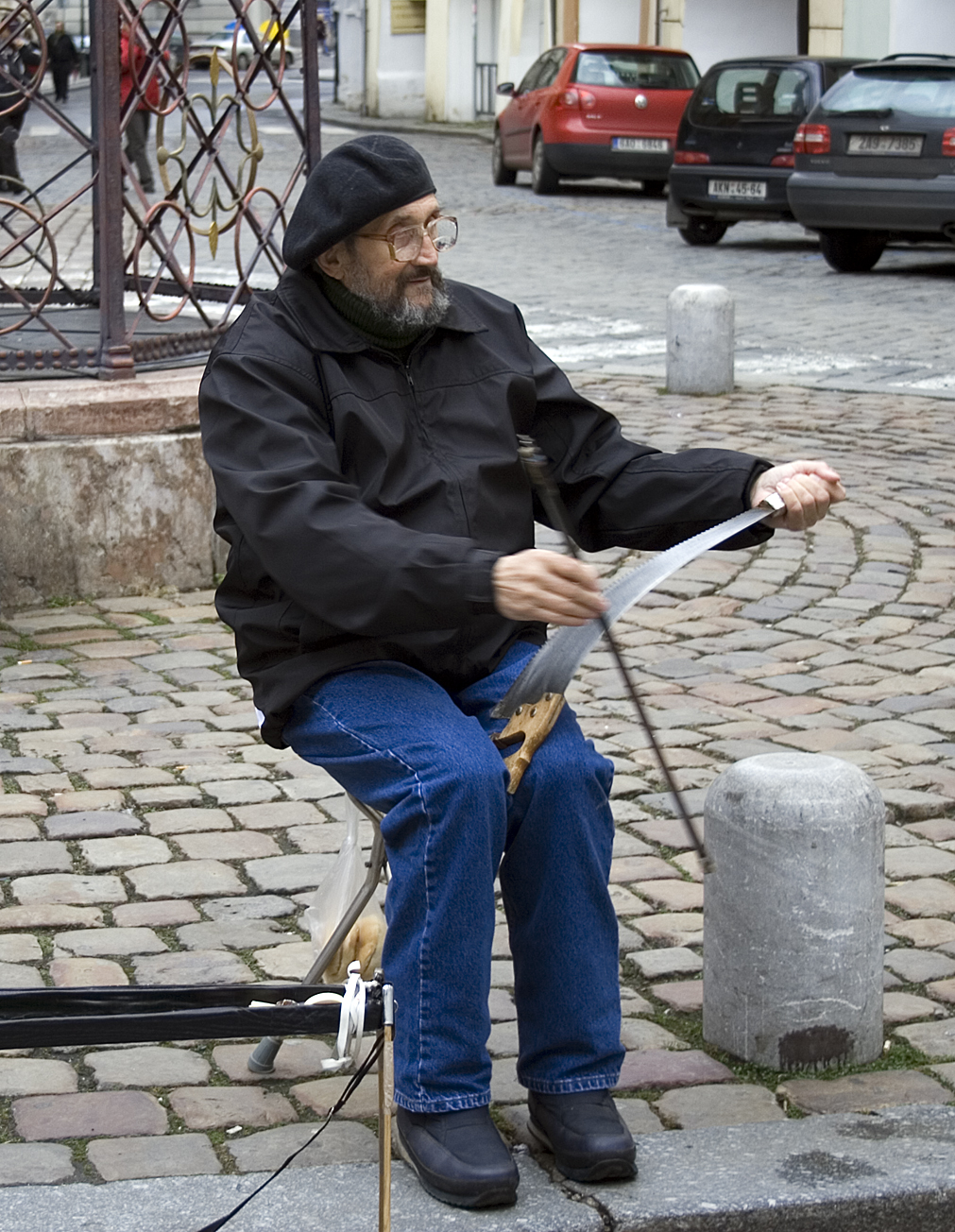 A busker playing a musical saw in Prague
